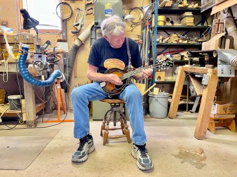  Don MacRostie plays one of the Red Diamond mandolins he made last year. He hand crafted the instrument in his workshop in Athens County.